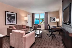 a hotel room with a desk and a living room at Delta Hotels by Marriott Sault Ste. Marie Waterfront in Sault Ste. Marie