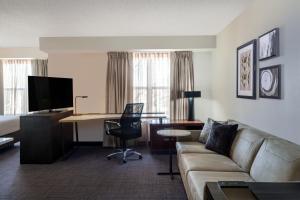 a living room with a couch and a desk with a computer at Residence Inn by Marriott Boulder Broomfield in Louisville