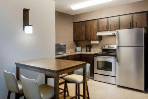 cocina con mesa y nevera de acero inoxidable en Residence Inn by Marriott Boulder Broomfield en Louisville