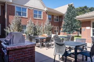 eine Terrasse mit Tischen, Stühlen und einem Grill in der Unterkunft Residence Inn by Marriott Boulder Broomfield in Louisville