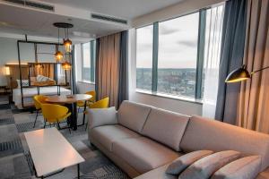 a living room with a couch and a table at Courtyard by Marriott Katowice City Center in Katowice
