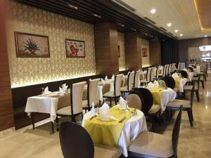 a dining room with tables and chairs with yellow table cloth at Crixus Duhok in Duhok