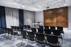 une salle de conférence avec des chaises et un podium dans l'établissement Courtyard by Marriott Katowice City Center, à Katowice