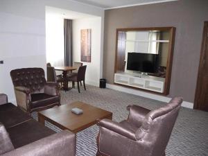 sala de estar con sofá, sillas y TV en Crixus Duhok en Duhok