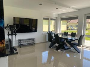 a dining room with a table and chairs and a tv at Domki u Ewy in Stronie Śląskie