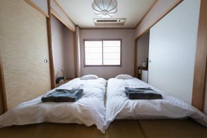 a bedroom with two beds with towels on them at azamianassobo in Asso