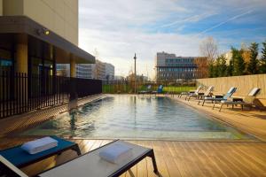 - une piscine avec des chaises longues dans un bâtiment dans l'établissement Residence Inn by Marriott Toulouse-Blagnac, à Blagnac
