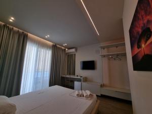 ein Schlafzimmer mit einem Bett mit zwei Handtüchern darauf in der Unterkunft Hotel Ble Ble Vlore in Vlorë