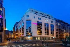 - un grand bâtiment blanc avec un panneau rose dans l'établissement Moxy Paris Bastille, à Paris