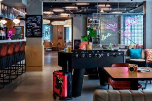 un restaurant avec un billard et une table avec une valise dans l'établissement Moxy Paris Bastille, à Paris