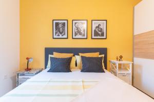 a bedroom with a bed with a yellow wall at Sea View Apartment Ana in Podstrana