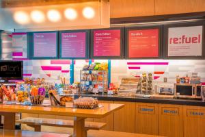 a fast food restaurant with a counter with food at Aloft Portland Airport Hotel at Cascade Station in Portland