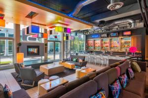 a bar in a restaurant with couches and tables at Aloft Portland Airport Hotel at Cascade Station in Portland