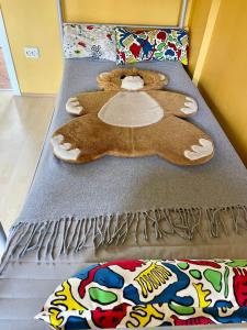 uma cama com um urso de peluche deitado sobre ela em Viktória Apartman em Balatonalmádi