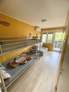 2 łóżka piętrowe w pokoju z żółtymi ścianami w obiekcie Viktória Apartman w mieście Balatonalmádi