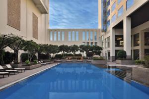 a large swimming pool in the middle of a building at Jaipur Marriott Hotel in Jaipur