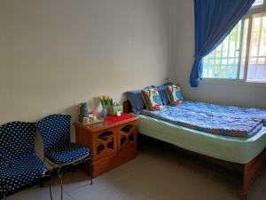 a small bedroom with a bed and two chairs at Taumi House in Puli