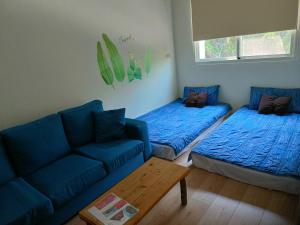 埔里鎮的住宿－山水桃米居，一间带两张床和一张沙发的客厅