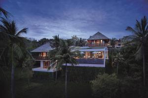 una casa en medio de un bosque con palmeras en The Ritz-Carlton, Koh Samui en Choeng Mon Beach