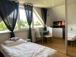 a bedroom with a bed and a desk and window at Domki u Ewy in Stronie Śląskie