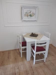 a white table and chairs in a room with a table at Apartman LISA in Niš +21 photos