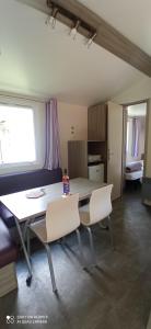 a dining room with a table and two chairs at Camping LE Moulin in La Motte-Chalançon