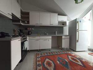 a kitchen with white cabinets and a refrigerator at Tarihi mekanlara metro ile ulaşım, Avm'lere Yakın in Istanbul