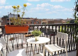 un balcón con mesa y sillas y una maceta con flores en Key Rome Center, en Roma
