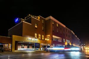 戴德伍德Four Points by Sheraton Deadwood的夜间驶过大楼的公共汽车