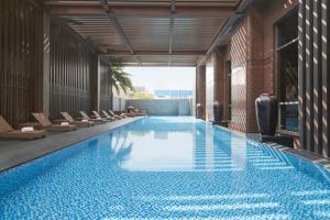 a swimming pool in a building with chairs at Sheraton Taitung Hotel in Taitung City