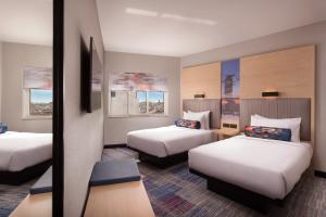 Habitación de hotel con 2 camas y espejo en Aloft Madrid Gran Via en Madrid