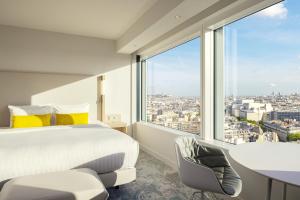 ein Schlafzimmer mit einem Bett und einem großen Fenster in der Unterkunft Courtyard by Marriott Paris Gare de Lyon in Paris