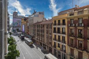 a city street with buildings and a bus at Aloft Madrid Gran Via in Madrid
