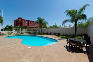 a swimming pool with a table and a table and a table and a tablektop at Wyndham Garden Monterrey Aeropuerto in Monterrey