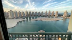 a view of a large body of water from a balcony at Beachfront Luxury Apartment-The Home-Pearl Island in Doha