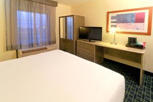 a hotel room with a bed and a desk with a television at Wyndham Garden Monterrey Aeropuerto in Monterrey