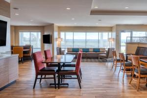 TownePlace Suites by Marriott Indianapolis Airport في انديانابوليس: غرفة طعام مع طاولة وكراسي وأريكة