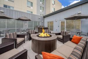 a patio with a fire pit and chairs and a building at TownePlace Suites by Marriott Indianapolis Airport in Indianapolis