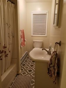 W łazience znajduje się umywalka, toaleta i prysznic. w obiekcie Saybrook Manor Beach House w mieście Old Saybrook