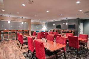 TownePlace Suites by Marriott Indianapolis Airport في انديانابوليس: قاعة اجتماعات مع طاولات خشبية وكراسي حمراء