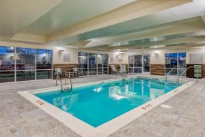 - une piscine d'eau bleue dans un bâtiment dans l'établissement TownePlace Suites by Marriott Indianapolis Airport, à Indianapolis