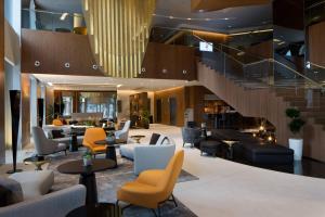 a lobby with couches and chairs and a staircase at Skopje Marriott Hotel in Skopje