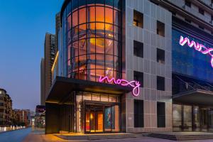 a building with a neon sign on the side of it at Moxy Xi'an Beilin in Xi'an