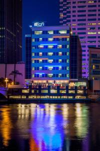un edificio iluminado junto a un río por la noche en Aloft - Tampa Downtown, en Tampa