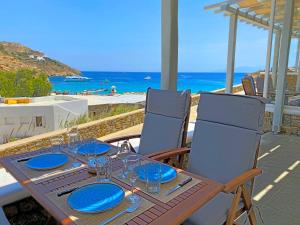 a wooden table with blue plates and glasses on it at 1Path Wave Mykonos Super Paradise Beach House in Mýkonos City