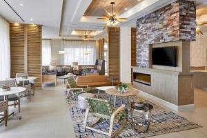 a lobby with a fireplace and tables and chairs at Residence Inn St. Petersburg Tierra Verde in Tierra Verde
