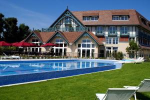 a hotel with a swimming pool in front of a building at Renaissance Paris Hippodrome de St. Cloud Hotel in Rueil-Malmaison