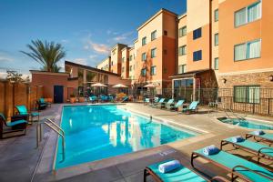 a pool at a hotel with chairs and a hotel at Residence Inn by Marriott Los Angeles Redondo Beach in Redondo Beach