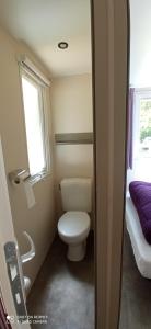 a small bathroom with a toilet and a window at Camping LE Moulin in La Motte-Chalançon