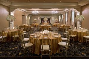 une salle de bal avec tables et chaises dans une pièce ornée de lustres dans l'établissement Hotel Colonnade Coral Gables, Autograph Collection, à Miami